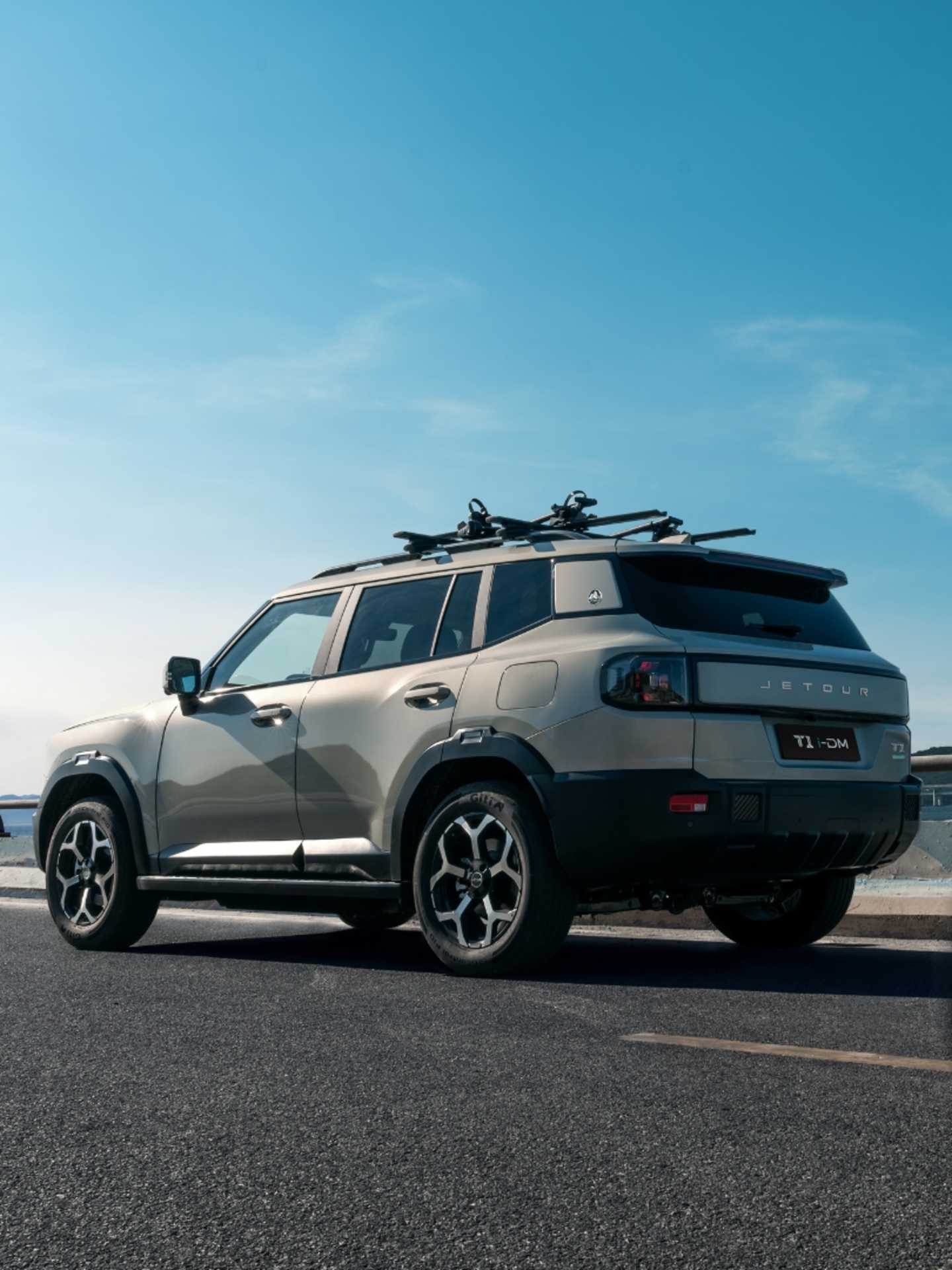 Jetour T1 IDM rear three-quarter exterior view with roof rack and rugged SUV styling